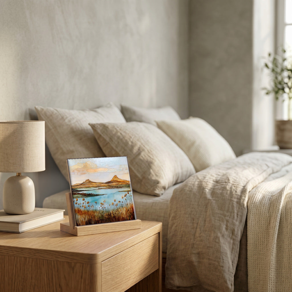 On the nightstand, on a light oak stand.